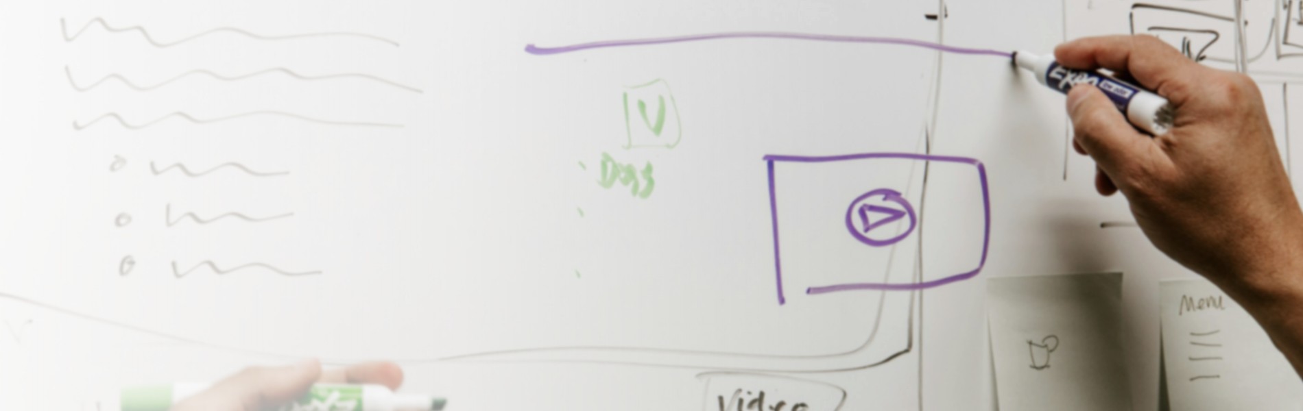 ホワイトボードに図を描きながら考えを整理する様子(エンジニアリング支援事業)